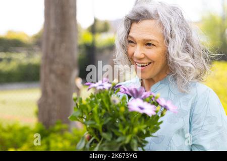 Vertical portrait of caucasian senior women spending time in the garden, planting Stock Photo