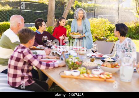 Happy caucasian family spending time together and having meal in the garden Stock Photo
