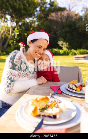 Caucasian mother and daughter spending time together and having christmas meal in the garden Stock Photo