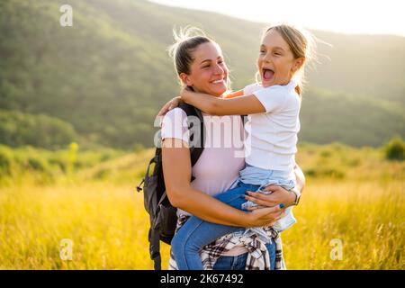 Happy mother and daughter enjoy spending time together in nature. Stock Photo