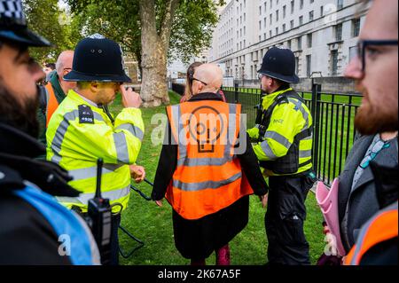 London, UK. 12th Oct, 2022. A woman is searched before the protest starts - Just stop oil continue a, possibly indefinite, daily protest in Westminster with the aim of getting the Government to stop all new oil fields. They march from Downing street every day. Credit: Guy Bell/Alamy Live News Stock Photo