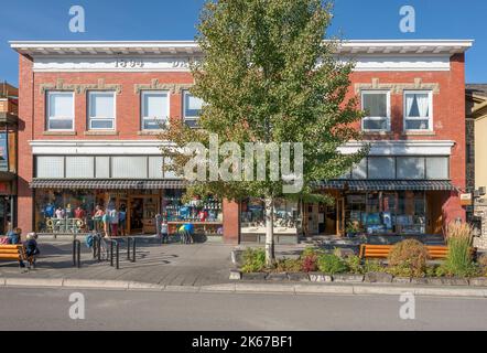 Banff, Alberta, Canada – October 07, 2022:  People gather outside a historic building on Banff Avenue Stock Photo