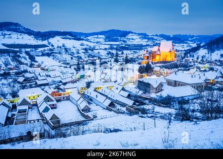 Biertan, Romania. Rural winter landscape in Transylvania with famous saxon church, travel background in Eastern Europe. Stock Photo