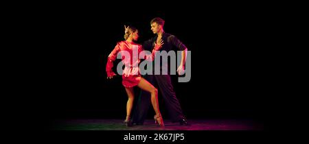 Feelings in dance. Emotional dancers dancing ballroom dance isolated on dark background. Concept of art, dance, beauty, music, style. Stock Photo