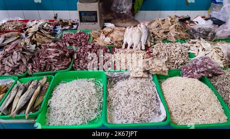 Close up top view of dried fish and squid on display of stall at traditional market in South Tangerang, Indonesia. No people. Stock Photo
