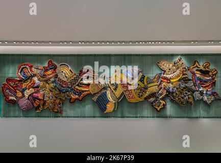 Bangkok, Thailand - Sep 30, 2022 : Artistic variety shade tone colors patterns of traditional thai textiles with decorative crafts and art on the wall Stock Photo