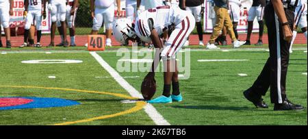 West Islip, New York, USA - 17 September 2022: A high school football kicker placing the football on a tee for kickoff. Stock Photo