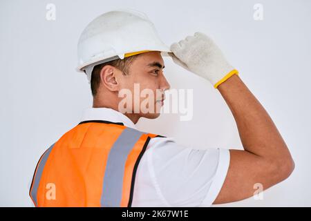 Portrait of an Asian construction worker tipping his hat facing right Stock Photo