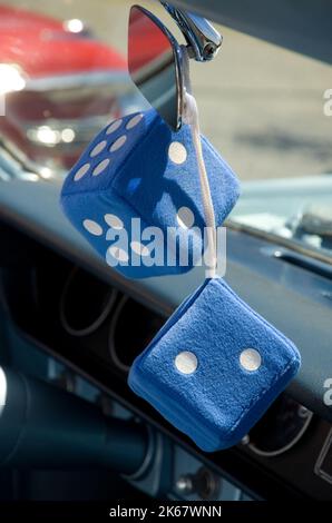 Large Decorative Retro Blue Dices Attached to a Car Rearview Mirror Vertical Stock Photo