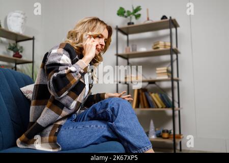 Cute middle-aged woman is emotionally talking on the phone Stock Photo