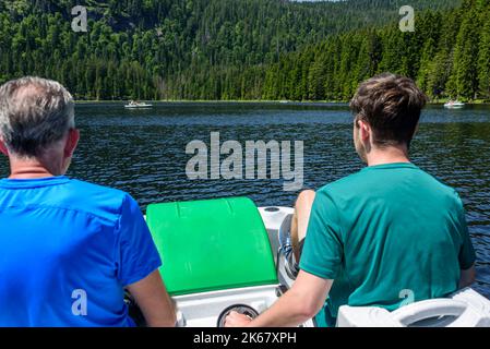 Father and son on the way on lake with water bike Stock Photo