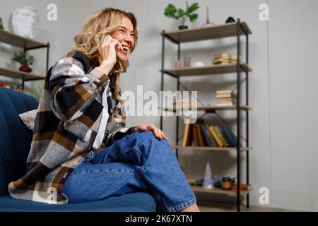 Beautiful caucasian mature woman talking on cellphone at home Stock Photo