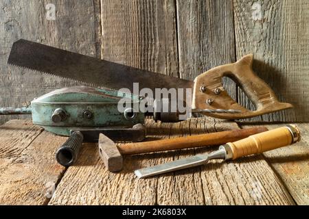 A set of tools on a wooden board. Industrial objects on a gray background. Vintage Hand Drill Stock Photo