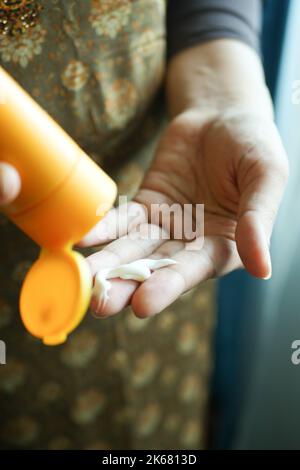 Close up of women hand using sunscreen cream  Stock Photo