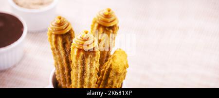 Churros, typical fried sweet from Brazil, Mexico and Spain, made from wheat flour and water, sprinkled with a layer of sugar or cinnamon, filled with Stock Photo