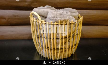 A basket with blankets in a wicker basket. indoor sauna accessories Stock Photo