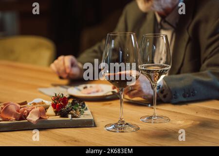 People drinking wine and eating cold cut meat in a wine cellar. Stock Photo