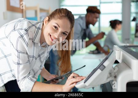 happy young woman on printer maintenance Stock Photo