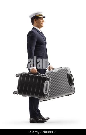 Full length profile shot of a pilot in a uniform carrying suitcases isolated on white background Stock Photo