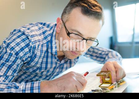 worker in printing and press centar uses a magnifying glass Stock Photo