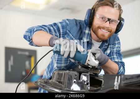 male mechanic using an angle grinder Stock Photo