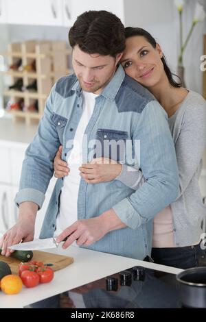 loving joyful young couple embracing and cooking together Stock Photo