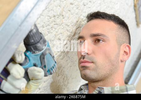 Closeup of man using drill Stock Photo