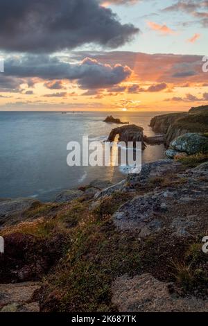 sunset at lands end cornwall with enys dodnan and the armed knight rock formations vert format long exposure Stock Photo