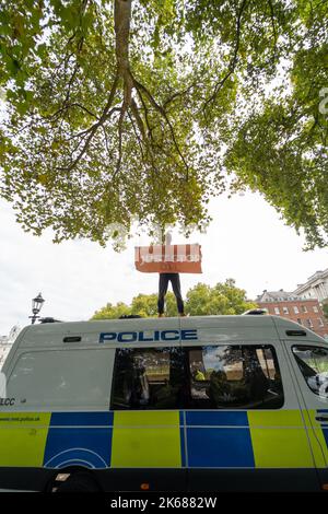 Two Just Stop Oil supporters climbed on top of a Metropolitan Police van outside Horse Guards Road in London on Wednesday (October 12) amid an ongoing Stock Photo