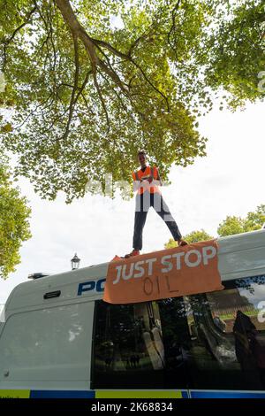 Two Just Stop Oil supporters climbed on top of a Metropolitan Police van outside Horse Guards Road in London on Wednesday (October 12) amid an ongoing Stock Photo