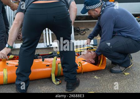 Two Just Stop Oil supporters climbed on top of a Metropolitan Police van outside Horse Guards Road in London on Wednesday (October 12) amid an ongoing Stock Photo