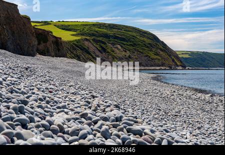 Scenic Pebble Beach and Sea View at Greencliff Beach, Showing Pebbles which stretch along the coast. Incoming Tide, Looking Towards Hartland Point Stock Photo