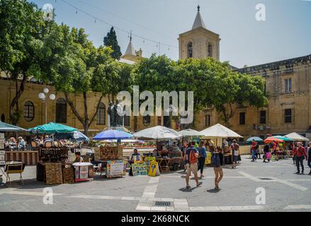 The market in Great Siege Square, Valletta, Malta. In the background is St. John's Co-Cathedral and the Great Siege Monument. Stock Photo