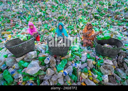 Workers sort used plastic bottles at a recycling factory. Recycle of plastics is the best way to make our environment clean and safe. Stock Photo