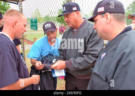 softball umpires school for ASA in the US during games and in pregame checking bats and lineups and rules and such Stock Photo