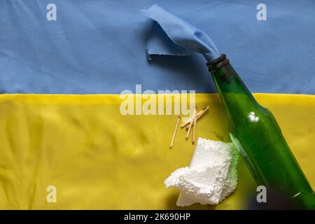 Molotov cocktail, martial law in Ukraine, a girl is preparing to defend her house, a combustible mixture in bottles with a rag lies on the flag of Ukr Stock Photo