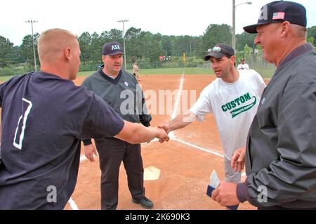 softball umpires school for ASA in the US during games and in pregame checking bats and lineups and rules and such Stock Photo