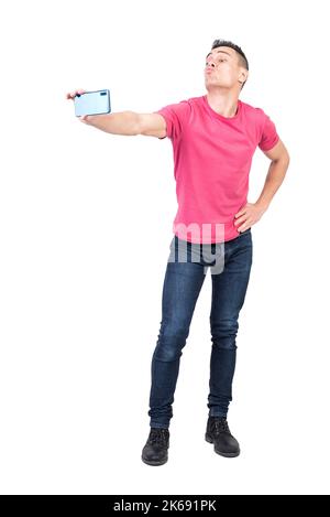 Joyful young male pouting lips and taking selfie against white background Stock Photo