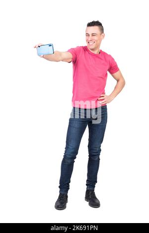 Smiling young man taking self portrait on smartphone in studio Stock Photo