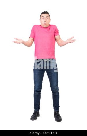 Young male shrugging shoulders and looking puzzled in studio Stock Photo