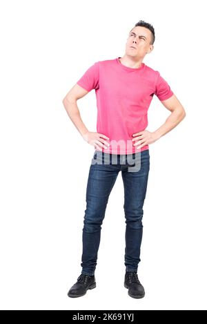 Thoughtful man standing with hands on waist and looking away Stock Photo