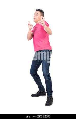 Cheerful young man pointing at camera in white studio Stock Photo