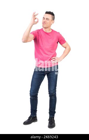 Self assured young guy showing OK gesture in white studio Stock Photo