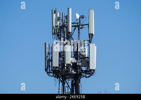 Cell phone, mobile phone telecommunication tower with antennas on blue sky Stock Photo