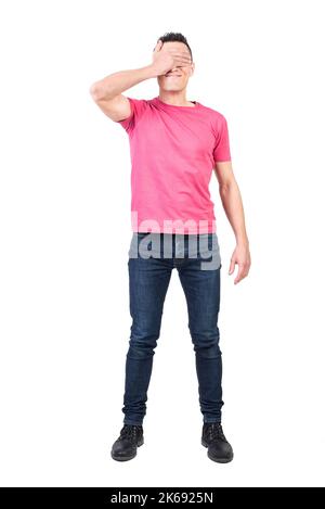 Man covering eyes with hand in studio Stock Photo