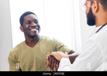doctor and male patient talking at office consultation for further treatment Stock Photo