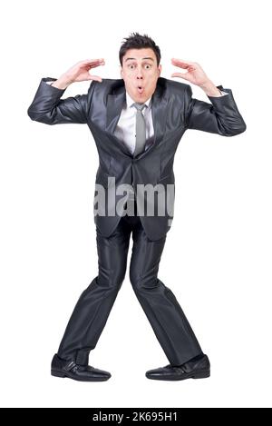 Full length of funny young male employee with dark hair making face and gesturing against white background Stock Photo