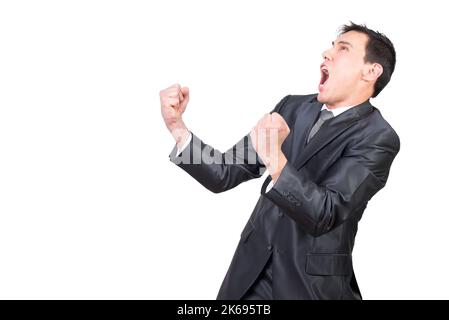 Excited young businessman yelling while celebrating success in studio Stock Photo