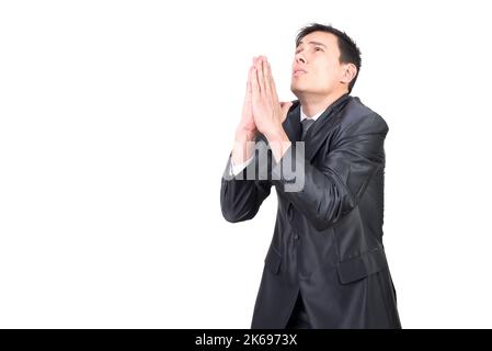 Young male manager in formal suit praying Stock Photo