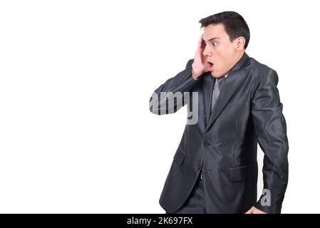 Astonished man in suit touching cheek in studio Stock Photo